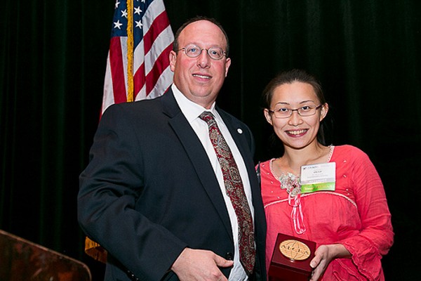 In December, Chris Cusano, chapter president, recognizes Chi-Lai Poon as a Distinguished Young AFCEAN.